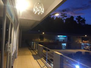 a balcony of a building at night with a chandelier at The Second Room in Ranau