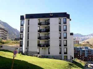 a building on a hill with a green field in front of it at Appartement Tignes-Le Lavachet, 2 pièces, 4 personnes - FR-1-411-746 in Tignes