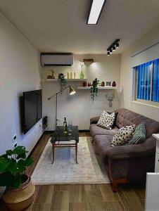 sala de estar con sofá y mesa en ירוק במושב, en Ma‘oz Ẕiyyon