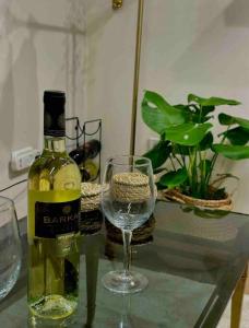 una botella de vino y una copa de vino en una mesa en ירוק במושב, en Ma‘oz Ẕiyyon