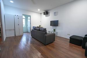 een woonkamer met een bank en een flatscreen-tv bij Aimelia guest house by G traveler in Petaling Jaya