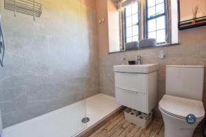 a bathroom with a shower and a toilet and a sink at Poxwell Manor West Wing - Exclusive Dorset Retreat in Poxwell +20 photos