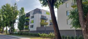 a white building with colorful balconies on a street at Happiness Apartman in Kecskemét