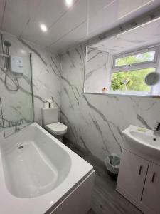 a white bathroom with a sink and a toilet at Riverview Cottage in Lanark