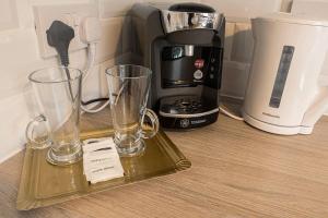 a tray with two glasses and a coffee maker on a counter at Riverview Cottage in Lanark