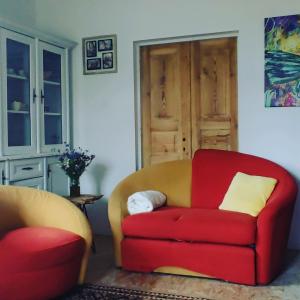 uma sala de estar com um sofá vermelho e uma cadeira em Agroturystyka Domek na wsi 44 