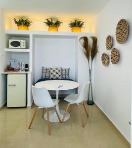 a dining room with a table and two chairs at Mykonian Starling - Town n' Sunset View Apartment in Mýkonos City