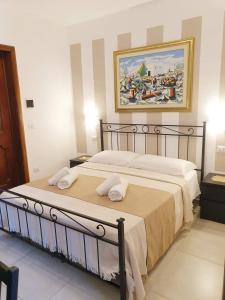 a bedroom with a bed with a painting on the wall at Chalet del Mare in Porto Cesareo