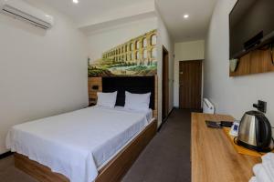 a bedroom with a large bed and a television at Acar Airport Hotel in Arnavutköy