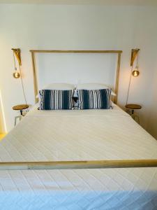 a bedroom with a large bed with two lamps at Mykonian Starling - Town n' Sunset View Apartment in Mýkonos City
