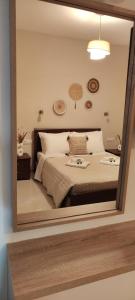 un miroir reflétant une chambre avec un lit dans l'établissement Serene, slow living house, à Orné