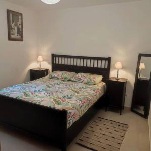 a bedroom with a bed with two night stands and a mirror at BOHO location 1 in Bonnieux