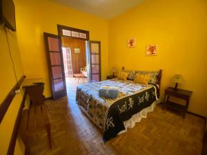 a bedroom with a bed in a yellow room at Hotel Philipp in Teresópolis