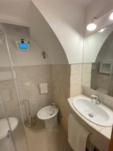 W łazience znajduje się umywalka, toaleta i prysznic. w obiekcie La Casetta di Lucia w Alberobello