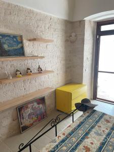 salon z żółtą szafką i półkami w obiekcie La Casetta di Lucia w Alberobello
