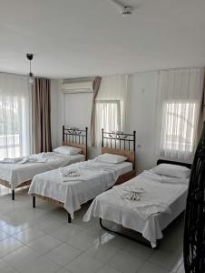 a group of four beds in a room at OTEL A in Çeşme