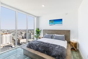 una camera con un grande letto e ampie finestre di Top Floor High Rise 3 Bed DTLA Skyscraper Penthouse a Los Angeles