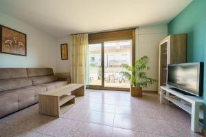 uma sala de estar com um sofá e uma televisão em HomeHolidaysRentals Anglada - Costa Barcelona em Santa Susanna
