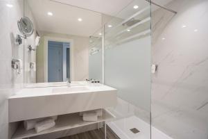 a white bathroom with a sink and a glass shower at HF Ipanema Park in Porto