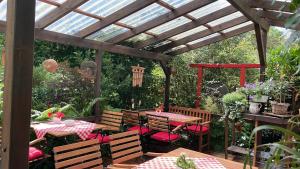 a patio with tables and chairs under a wooden pergola at Pension Rosenhof in Soltau