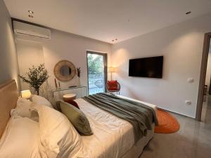 a bedroom with a bed and a tv on the wall at O live Kalamata in Kalamata