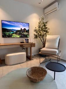 a living room with a couch and a tv on the wall at O live Kalamata in Kalamata