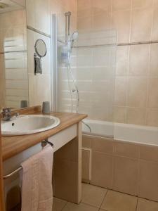 ein Badezimmer mit einem Waschbecken, einer Dusche und einer Badewanne in der Unterkunft Hôtel Le Boïate in Arès