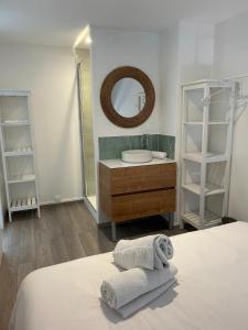 een badkamer met een bed, een wastafel en een spiegel bij La Pause 800 in Wissant