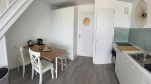 - une cuisine avec une table et des chaises dans la chambre dans l'établissement La Pause 800, à Wissant