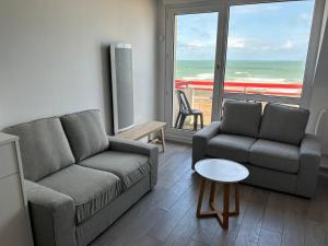 a living room with a couch and a chair and a table at La Pause 800 in Wissant