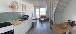 a kitchen and a living room with a table at La Pause 800 in Wissant