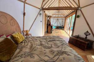 ein Schlafzimmer mit einem großen Bett in einem Zelt in der Unterkunft The Island of Xanadu in Beaworthy