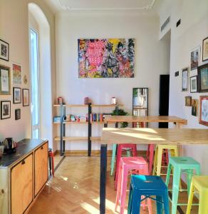 a room with a table and some colorful stools at 5 Terre Backpackers City in La Spezia