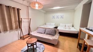a living room with two beds and a couch at UDEE Cozy Hotel in Chiang Mai