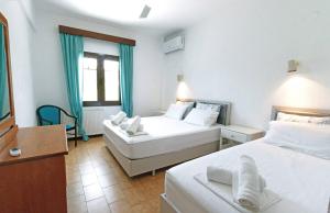 Habitación de hotel con 2 camas y TV en Villa Paradiso, en Neos Marmaras