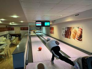 a man playing bowling in a bowling alley at Tölgyes - völgy Vendégház in Makkoshotyka