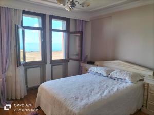 Schlafzimmer mit einem Bett und Strandblick in der Unterkunft Gündoğdu 