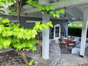 eine Terrasse mit einem Tisch, Stühlen und einem Baum in der Unterkunft Hiša odprtih vrat in Tolmin