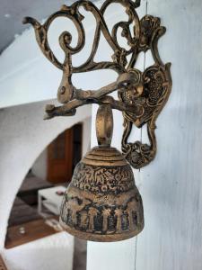 une cloche suspendue à un mur dans une pièce dans l'établissement Hiša odprtih vrat, à Tolmin