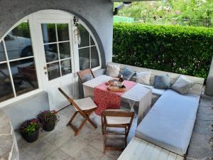 patio ze stołem, krzesłami i kanapą w obiekcie Hiša odprtih vrat w mieście Tolmin