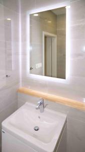 a white bathroom with a sink and a mirror at TOP apartmán Novohradské hory in Černé Údolí