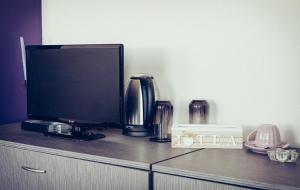 a tv on top of a dresser with at Bogdanovi Guest House in Chernomorets