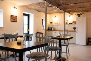 a restaurant with tables and chairs and a kitchen at Berits Bed and Breakfast in Haderslev