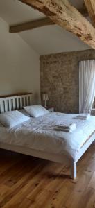 1 dormitorio con 1 cama blanca y suelo de madera en Les Vents d’Anges, en Clussais-la-Pommeraie