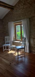 Habitación con 2 sillas, mesa y ventana en Les Vents d’Anges, en Clussais-la-Pommeraie
