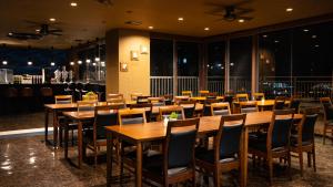 uma sala de jantar cheia de mesas e cadeiras de madeira em Rycom Crystal Hotel em Okinawa