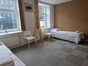 a bedroom with a bed and a ladder and two chairs at Room near City Center Harbour in Tallinn