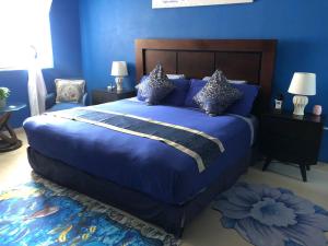 um quarto azul com uma cama grande com lençóis e almofadas azuis em Villa Segovia em Cozumel