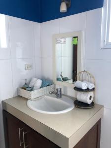 uma casa de banho com um lavatório e um espelho em Villa Segovia em Cozumel