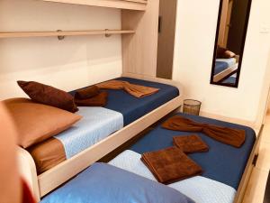 two beds in a small room with a mirror at Grand Harbour View Lookout in Kalkara